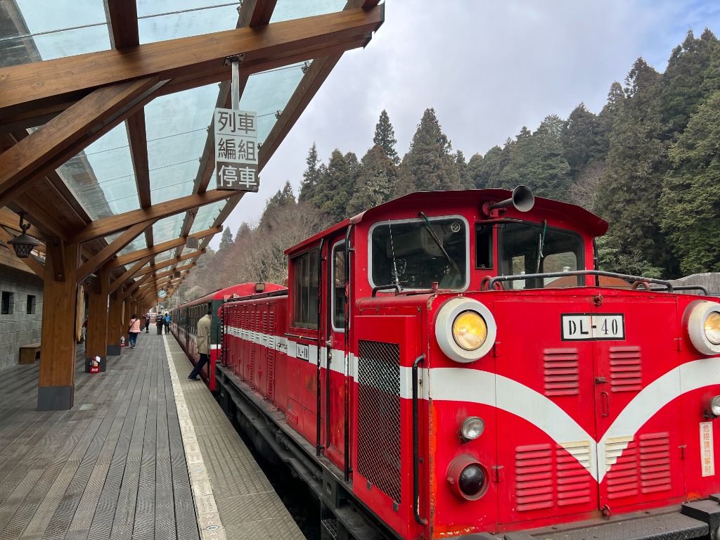 Locomotive rouge DL-40 du train forestier d'Alishan en gare sous une verrière en bois