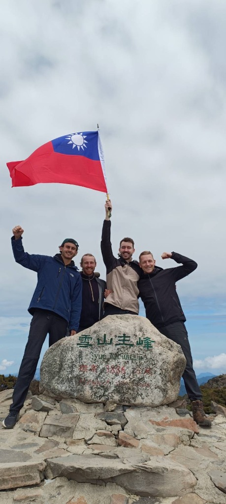 Quatre randonneurs au sommet de Xueshan à 3886 m avec le drapeau taïwanais